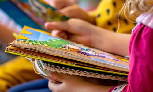 closeup-hands-holding-books-reading-session-with-children-job-id-a73a2c8227144733b9de971796d56b0d