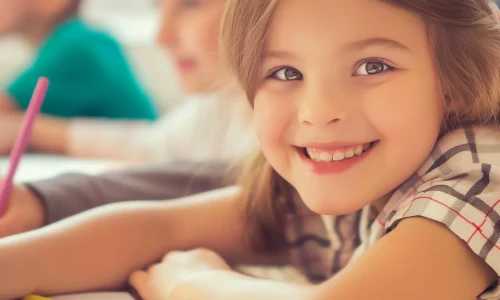 girl-with-smile-her-face-is-smiling-sitting-front-her-back-school
